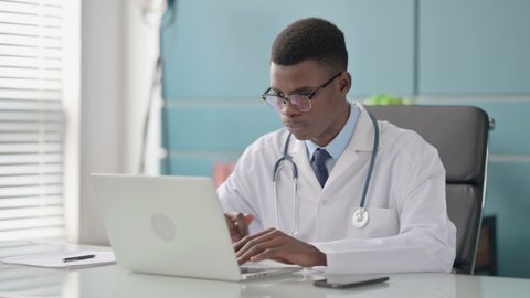 Young African Doctor Working on Laptop in Office