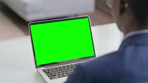 Young African Businessman Using Laptop with Green Screen