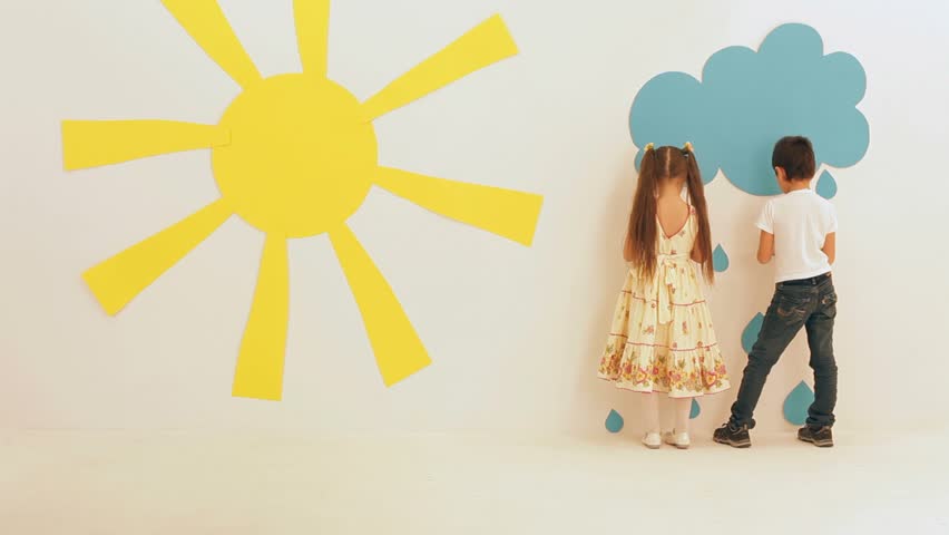 Two kids removing decorations. Studio