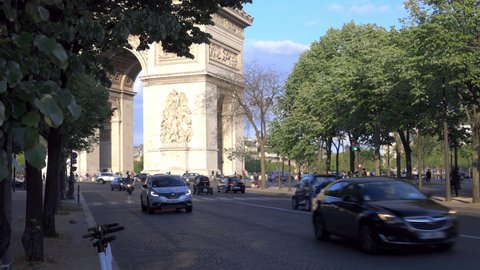 Paris, France - May 2019 : Arc de Triomphe seen from the end of the Avenue Foch and cars driving in Paris, France 
