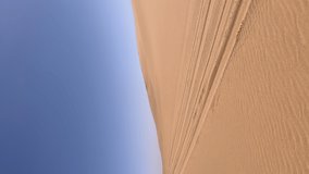 Vertical video. Car driving sand dunes. Dune driving in desert. Indoors white SUV auto off road travel in Africa or UAE. Sunny day. Summer vacation, trip safari.
