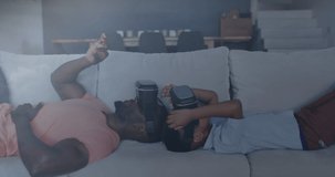 Animation of constellations over happy african american father and son wearing vr headsets. family, togetherness, spending quality time concept digitally generated video.
