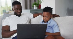 Animation of subscribe over happy african american father and son using laptop. family, togetherness, spending quality time concept digitally generated video.