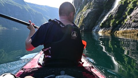 Geiranger, Norway - 23.08.2021: Beautiful waterfalls comming down on the Geirangerfjord in Norway while kayaking