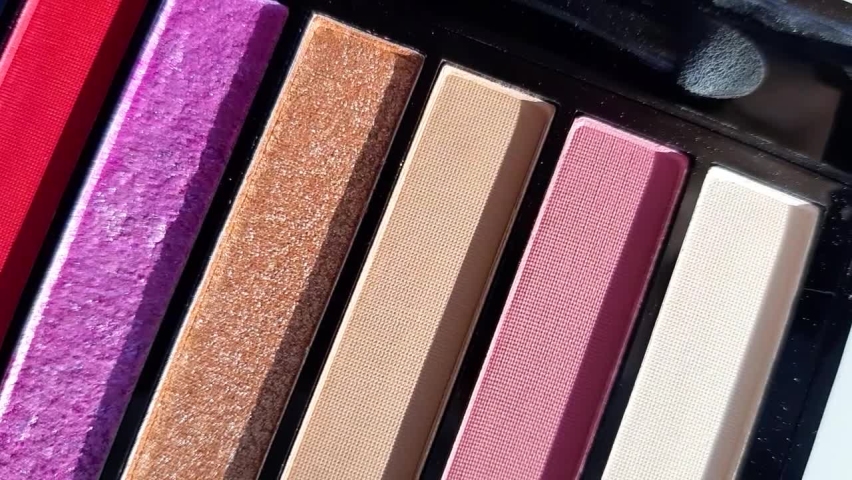 slow motion. a palette of bright eye shadows in close up, view top