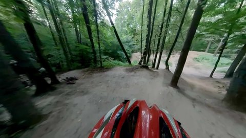 Jumps on a mountain bike filmed by an action camera mounted on an athlete performer