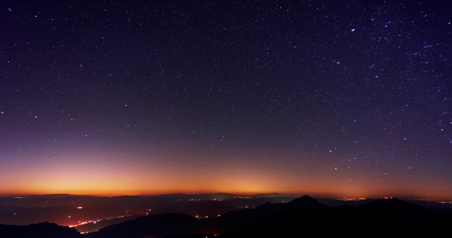 The stars revolve in the starry night sky over the mountains. 4K timelapse video  Royalty-Free Stock Footage #1087919807