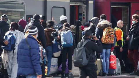 Bucharest, Romania - March 03, 2022:  Ukrainian refugees and african students from Ukraine board the train to Vienna at the North Railway Station, to escape  insane war against Ukraine