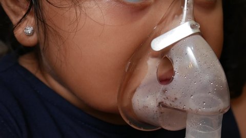 Asian girl about 4 years old is being nebulized to cure her respiratory tract.