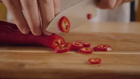 Close view man's hand chopping red fresh pepper with sharp knife. Chef is cutting green sweet paprika. Healthy Food Concept. Preparing Vegetable for salad. High quality 4k video.