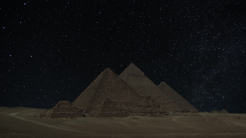 The Giza Great Pyramid complex in Egypt near Cairo under night sky with stars, timelapse 4k