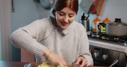 Happy Young Italian girl preparing the dough for homemade potato gnocchi