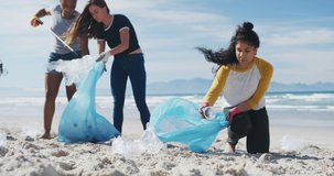Animation of flowers over diverse female and male volunteers picking up rubbish on beach. eco conservation volunteers, beach clean-up concept digitally generated video.