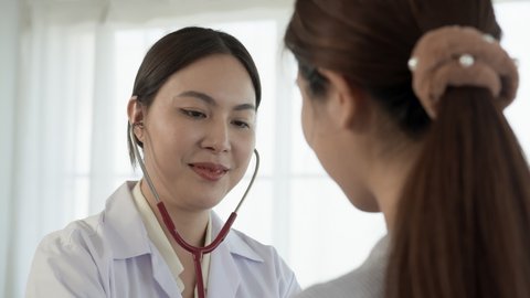 4K 50fps, Asian female doctor applying a stethoscope to patient's chest Listen to the heart to know the patient's symptoms.