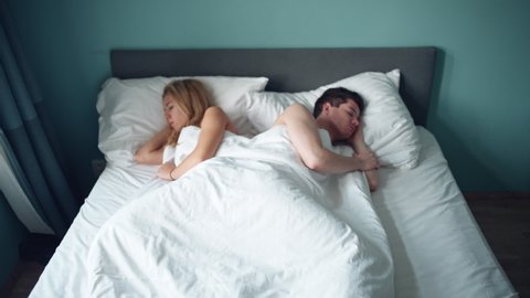Sad woman and man, husband in bed, lack of sexual activity in family. Young unhappy couple having problem in bedroom, quarrel between lovers. Divorce, marriage, conflict, family crisis, love concept.
