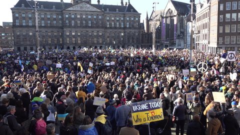 AMSTERDAM, NETHERLANDS – FEBRUARY 27 2022: Thousands of people gather to protest against Russian invasion of the Ukraine. Anti-war demonstration on the Dam Square in Amsterdam, the Netherlands