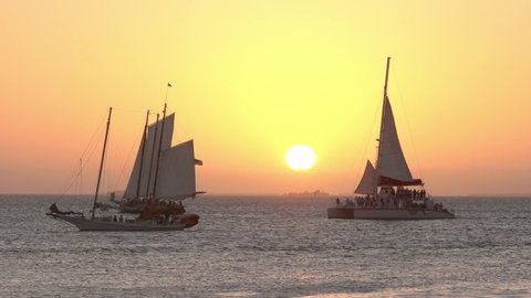 Wonderful sunset on Key West - typical view with sailing boats in the sun - KEY WEST, USA - FEBRUARY 14, 2022