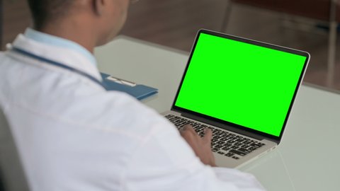 Young African Doctor Using Laptop with Green Screen