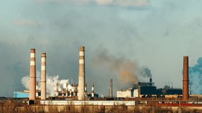 Сarbon dioxide emissions from heavy industry footage time lapse. Smoking chimneys 4k time lapse. Background video of smoking chimneys of industrial factory and blue sky.