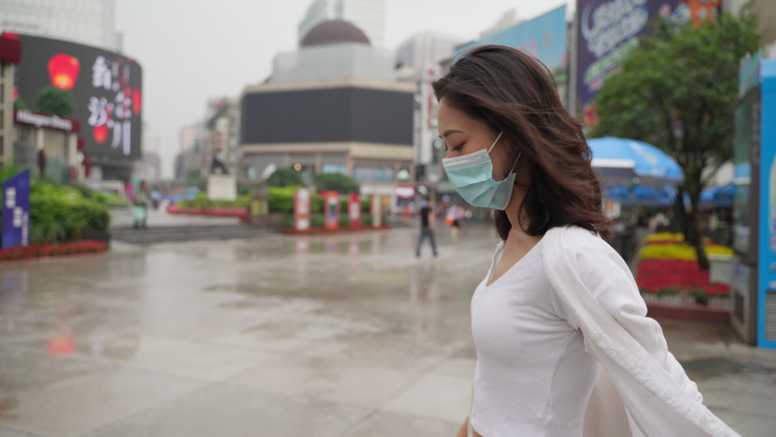 Chinese Young Woman Wearing a Medical Mask and White Shirt Walking in Downtown Street in Chengdu Sichuan China