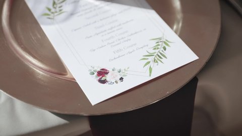 Gold plate and menu place setting for a dinner at a wedding venue.