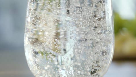 Sparkling water. In this close up macro shot you can see glass filled with sparkling mineral water and ice cubes.
