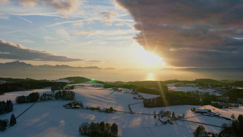 Swiss Winter Countryside At Sunset With Lake Leman And Alps In Background In Vaud, Switzerland - aerial drone shot