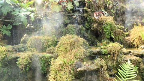 Waterfall in a relaxing tropical garden A mist of water vapor stock video footage
