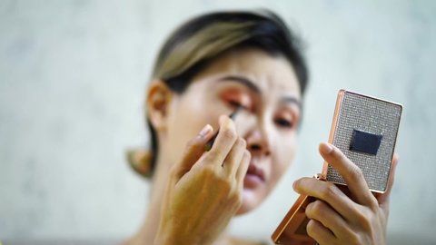 Asian woman doing makeup Focus on eyeliner, inliner, close-up shots
