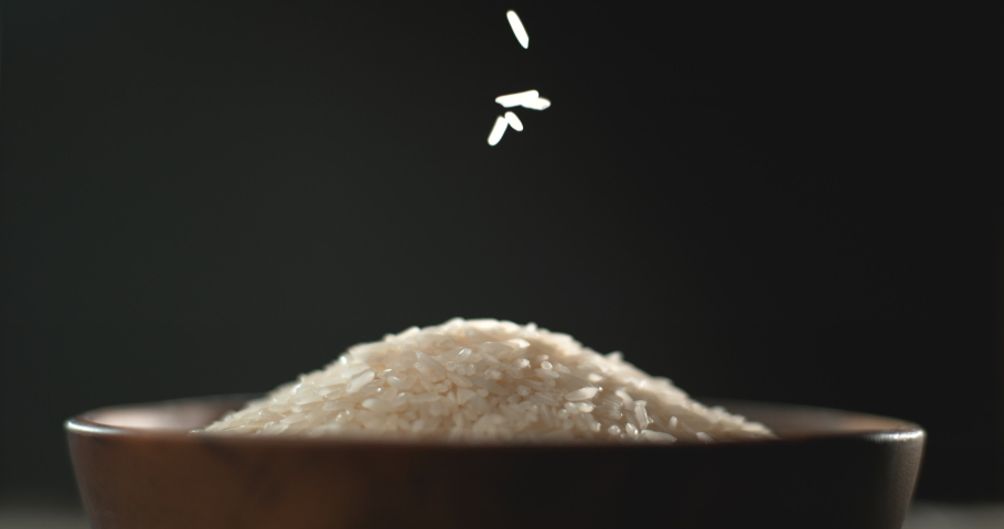 Close up of rice grains falling into a bowl in super sloe motion  Royalty-Free Stock Footage #1087965851