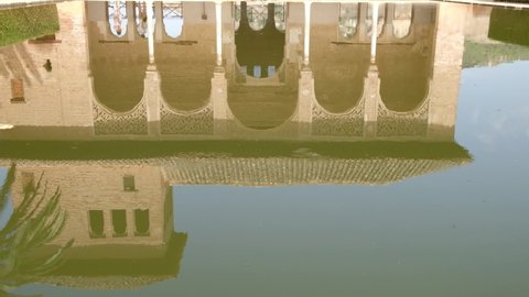 Granada, Spain, 31.08.2021: Garden of the Partal,  Alhambra Granada. Reflection in the water. Moorish Architecture. Unesco Unesco World Heritage Spain. Travel in time and discover history. 
