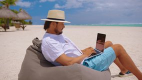 Man is typing on the keyboard on the background of a beautiful beach. NFT crypto, non fungible token of unique artist collectibles, blockchain and digital artwork selling technology symbol. - Powered by Shutterstock - Get 15% off with code: PIKWIZARD15