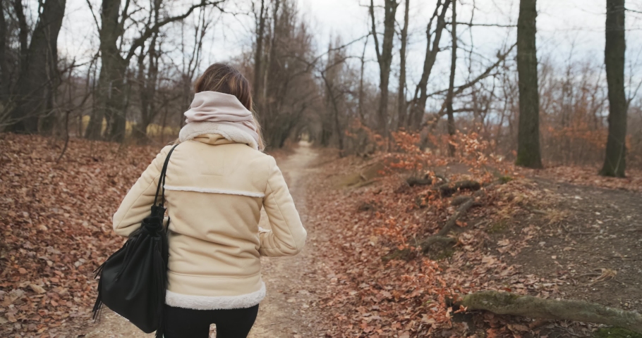 Camera following woman on forest path slow motion