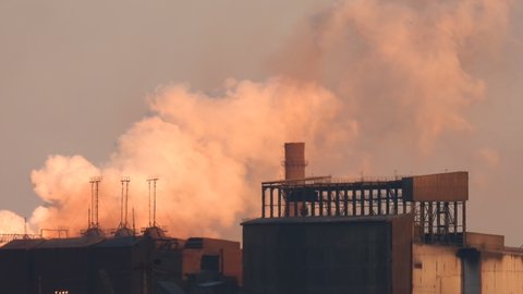Tubers of smoke at a metallurgical plant at dawn 4k. White smoke from chimneys in the air at dawn. Air pollution from factory. Environmental pollution.