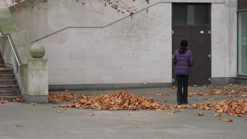 Woman play racquetball alone in autumn street.