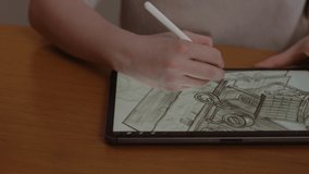 Talented young concept artist draws a sketch of a casual game on a digital pen