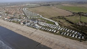 Aerial footage along the south coast by Bracklesham Bay and the holiday resort caravan park near East Wittering in West Sussex, Southern England.