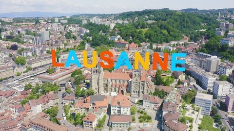 Inscription on video. Lausanne, Switzerland. Cathedral of Lausanne. La Cite is a district historical centre. Different colors letters appears behind small squares, Aerial View, Departure of the camer