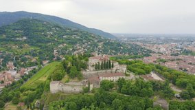 Inscription on video. Brescia, Italy. Castello di Brescia. Flight over the city in cloudy weather. Different colors letters appears behind small squares, Aerial View, Point of interest