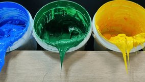 
yellow,green and blue ink slowly dripping from white bucket.
high quality video 4K. filming in the studio.
color and printing ink background.stock footage colorful paint concept,
