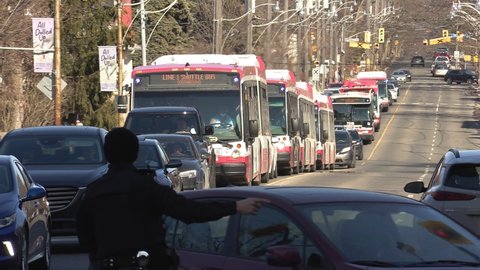Toronto, Ontario, Canada March 2022 Public transit buses stuck in gridlock car traffic in city streets