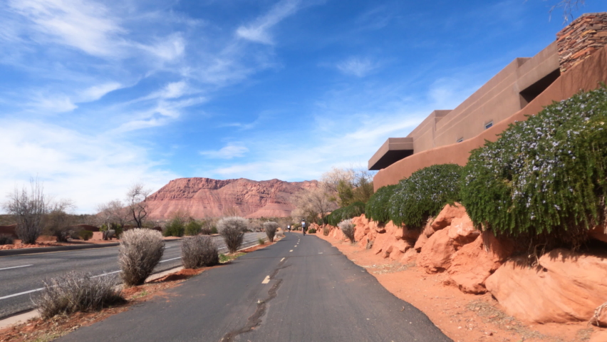 Riding bike trail St George Utah woman. Bicycle trails in St George southern Utah in desert and red rock landscape. Healthy Exercise on paths in urban mountains.