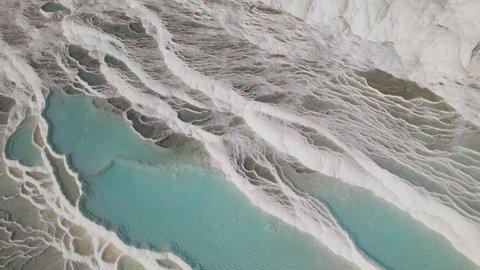 4K colour graded Travertines of Pamukkale - Denizli - Turkey. Flying over the travertines in Pamukkale, Turkey. White limestone mineral formations. Aerial footage 4k on a Sunny day
