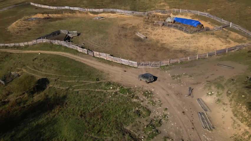 a car is driving along a road in a mountainous area, shooting from a drone