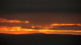 8K 7680X4320.Sunset through the dark clouds.Foggy smoke in front of the sun.Cloud is black color and in the form of thin long lines.Time lapse video of sunset only in orange and red hues.Beautiful 8K.