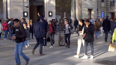 Paris, France - May 2019 : Crowd of tourists walking passing by the entrance of the Champs-Elysees Apple Store in Paris, France