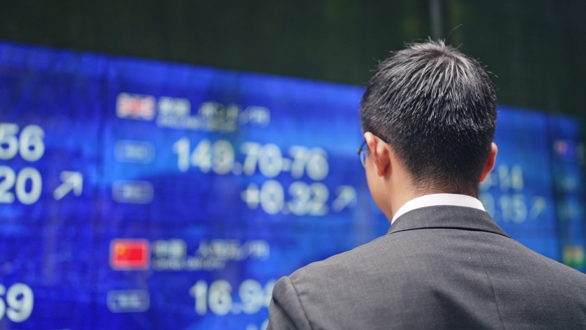 Depressed businessman in front of an electric bulletin board. Japanese translation: "yen","dollar","euro","pound" Royalty-Free Stock Footage #1087989783