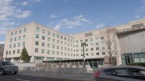 Washington, DC - USA March 2 2022: The headquarters of the United States Department of State (Harry S. Truman Building)  in Washington, DC. Left to right panning wide shot of the 23rd street entrance.