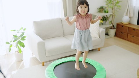 Asian child jumping on a trampoline.