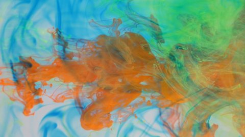 Liquid abstractions, the dissolution of blue, yellow, red and green paint in water.